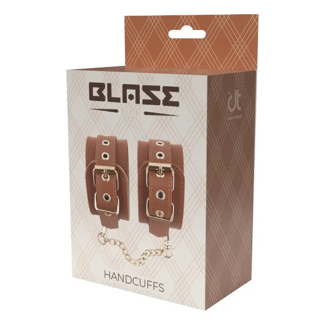 Cătușe DREAMTOYS Blaze Elite Handcuffs. pentru jocuri erotice. din piele ecologică. cu lanț auriu. culoare maro coniac