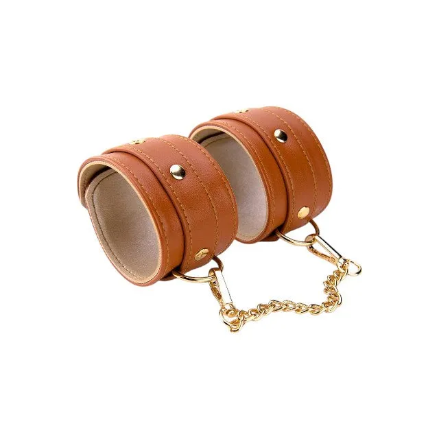 Cătușe DREAMTOYS Blaze Elite Handcuffs. pentru jocuri erotice. din piele ecologică. cu lanț auriu. culoare maro coniac